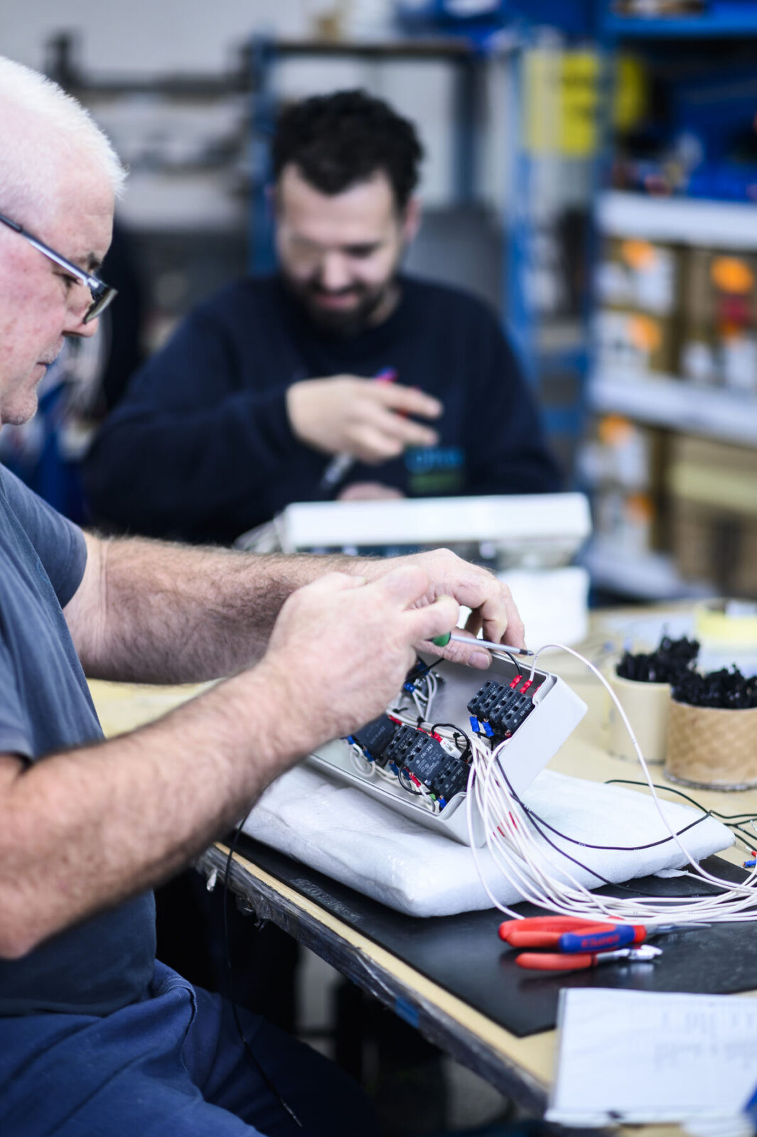 Dos profesionales de Oliver montando un cableado en su puesto